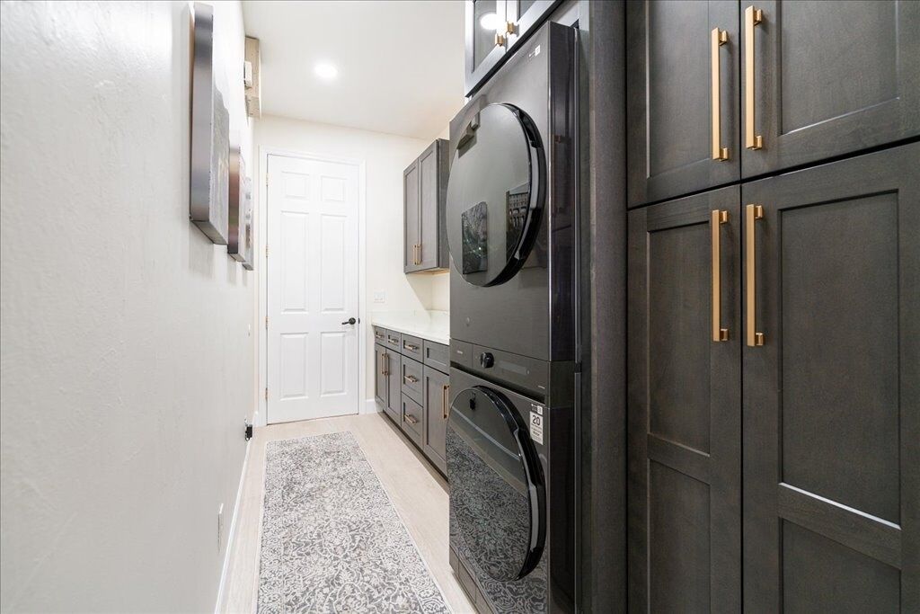 A narrow kitchen with dark cabinets, a refrigerator, and a microwave.