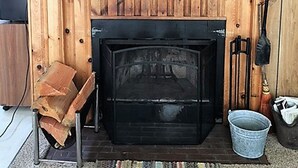 A wooden interior with a fireplace, a painting of a whale, and a rustic decor. - Classic Honeymoon Beach Cottage. Private, Romantic, Oceanfront.  Pet friendly. (Waldport)