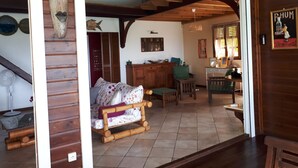 Un interior de madera con un sofá, una mesa de comedor y una escalera.