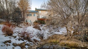 A house with a stone pathway leading to a small pond, surrounded by trees and shrubs. - Family Getaway~Hot Tub, Ice Castles & Tubing HS (Midway)