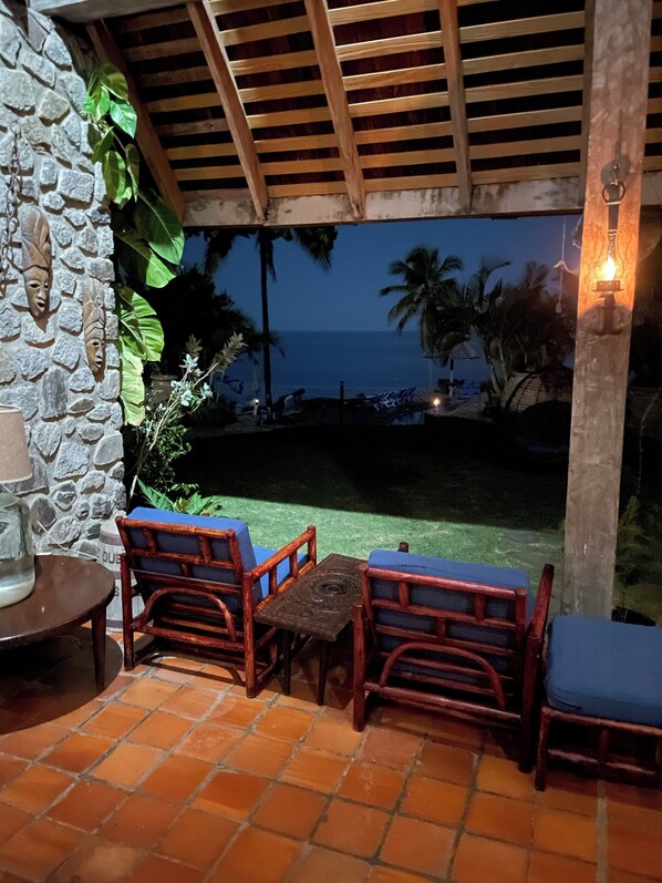 An outdoor patio with wooden furniture and a stone wall.