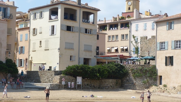 A coastal town with buildings, a beach, and a tower. - Place of the Strings in the heart of St Tropez apartment T2 new 2/4 with parking (Saint-Tropez)