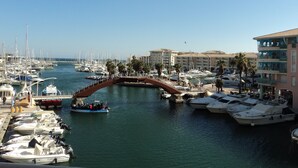 A marina with boats docked, a pedestrian bridge, and buildings in the background. - LOCATED APARTMENT IN PORT FREJUS (Fréjus)