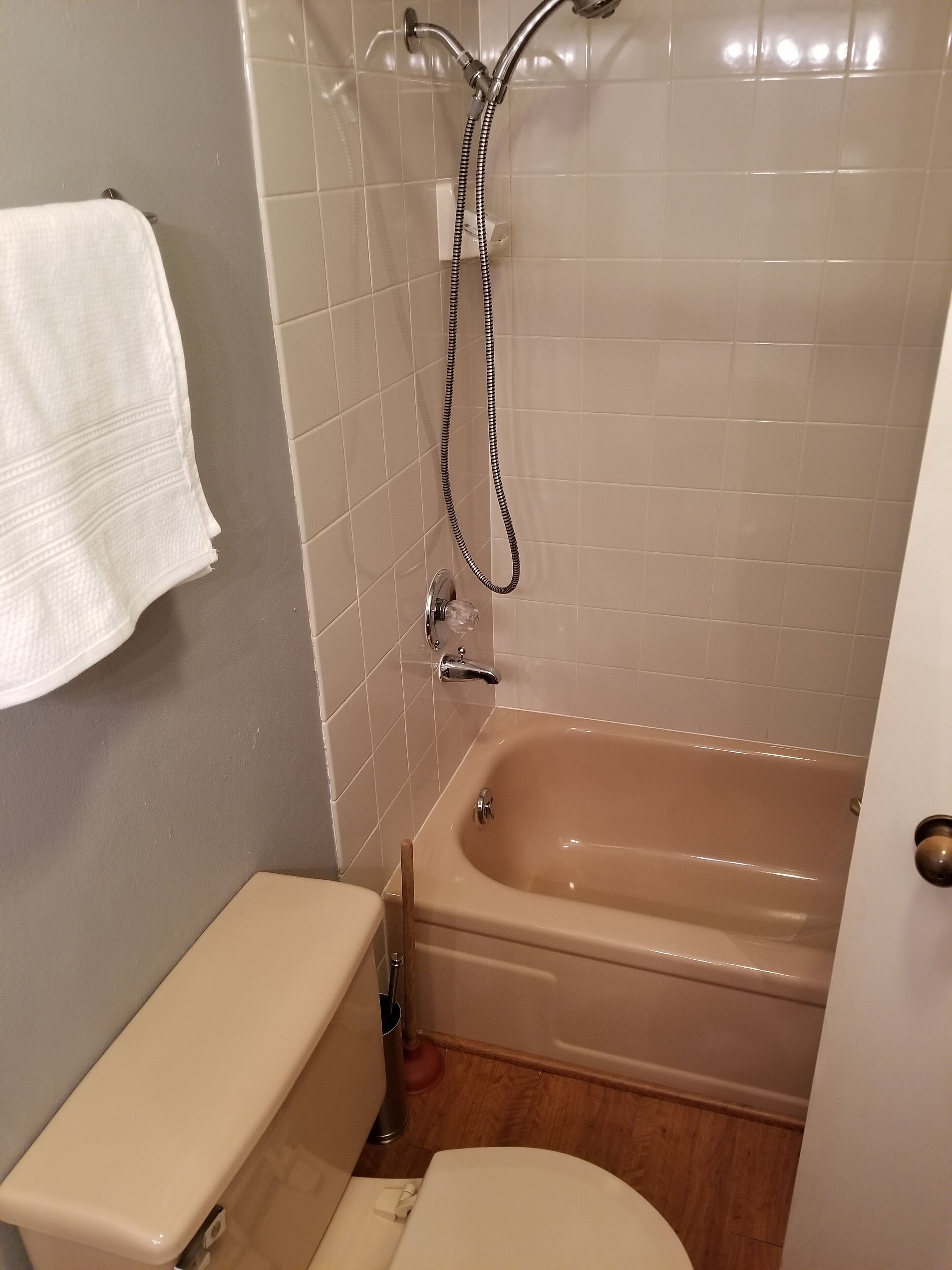 A bathroom with a bathtub, toilet, and shower.