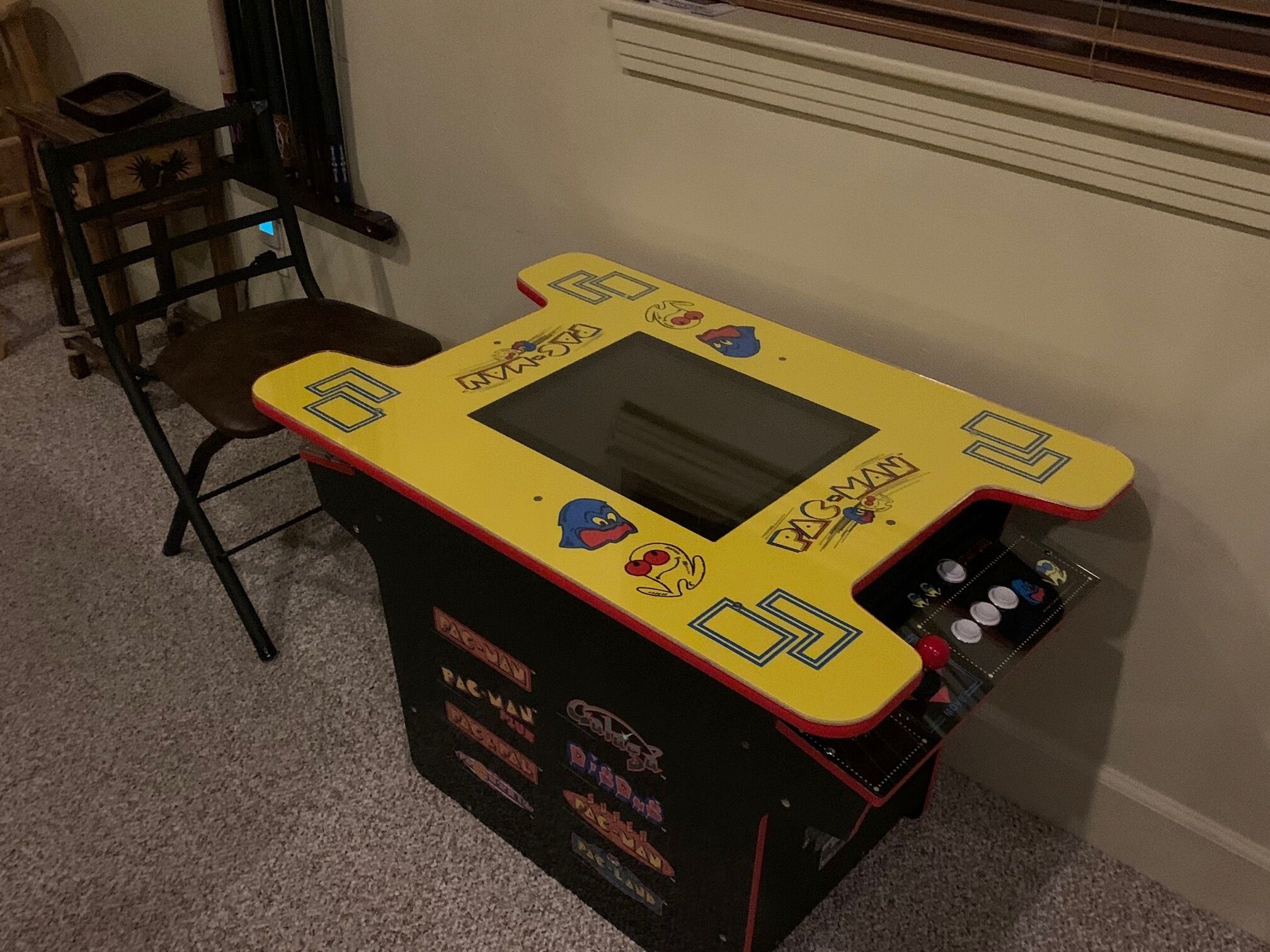 A Pac-Man arcade machine with a yellow top, black base, and red accents.