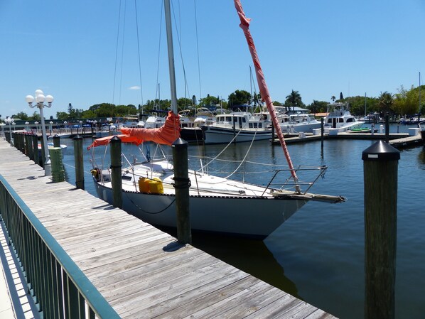 Un muelle de madera con un velero amarrado en un puerto deportivo.