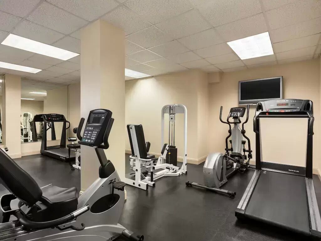 A gym with treadmills, elliptical machines, and weight equipment.