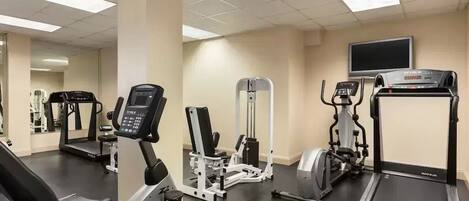 A gym with treadmills, elliptical machines, and weight equipment.