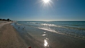 Ein Strand mit blauem Himmel und strahlender Sonne.
