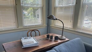 Een gezellige kamer met een houten tafel, een blauwe bank en een lamp.