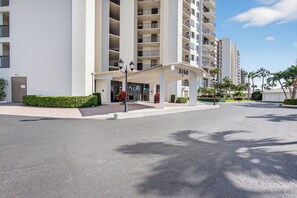 Un hôtel à plusieurs étages, doté d’une entrée couverte et offrant une vue sur un ciel dégagé.