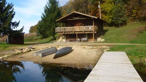 A cabin with a deck, a dock, and a small boat.