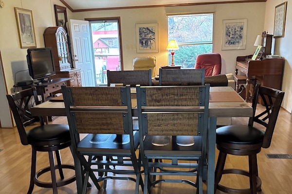 Dining room table, and den in background
