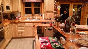 A kitchen with wooden cabinets, a sink, and various kitchen items. - Luxurious & Spacious!  A Great Place For Family, Friends, Reunions & Corporate! (Adams)