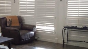 A living room with a leather sofa, a coffee table, and a rug. There are two deer heads mounted on the wall. - Whitetail Ranch Manor Retreat (Bryan)