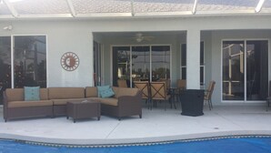 Un espace extérieur abrité comprenant une piscine, un canapé et une table à manger.
