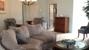 Un salon avec un canapé beige, une table basse ronde et un meuble en bois.