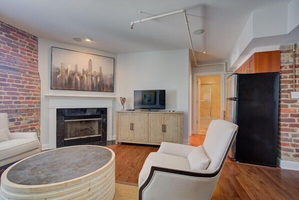 Una sala de estar con chimenea, televisor y zona de estar.