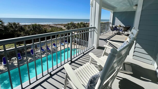 A balcony with a view of a swimming pool and the ocean. - Ocean Boulevard Oasis - Beachfront, Spectacular Ocean View, Pool, Beach Access! (Isle of Palms)