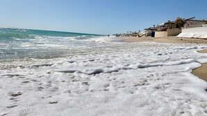 A beach with waves and a clear sky.