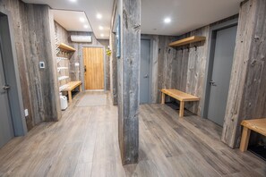 A hallway with wooden walls and floors, benches, and a door. - Pinnacle Ridge 23 - Ski in Ski out, Private Hot Tub, Gas Fireplace (Whistler)