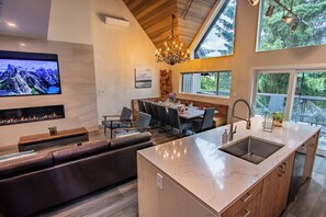 Una cocina moderna con una isla grande, un comedor con vistas y una chimenea.