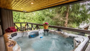 A hot tub with a wooden deck and a view of trees. - Pinnacle Ridge 23 - Ski in Ski out, Private Hot Tub, Gas Fireplace (Whistler)