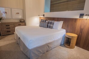 A modern bedroom with a large bed, wooden headboard, a round nightstand, and a wall-mounted light fixture. - Pinnacle Ridge 23 - Ski in Ski out, Private Hot Tub, Gas Fireplace (Whistler)