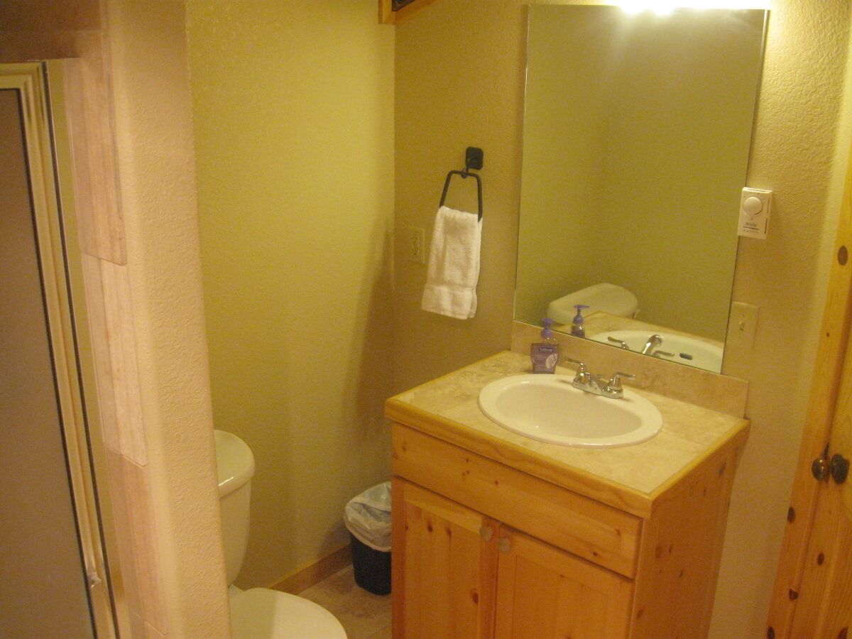A small bathroom with a toilet, sink, and mirror.