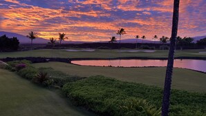 A golf course with a water hazard, palm trees, and a sunset sky. -  Access to Mauna Lani Spa/Tennis/Pickleball/Gym/Lap Pool included with booking (Waimea)