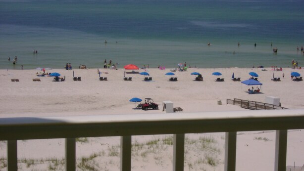 A beach with umbrellas and lounge chairs.