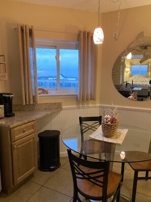 Enjoy a compact room with a kitchenette, dining space, and large window offering a view of the outside.