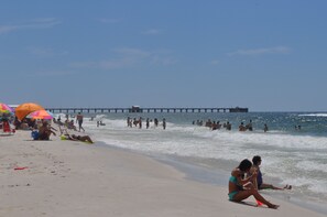 Guests can enjoy a serene beach experience with umbrellas providing shade and calm waters.