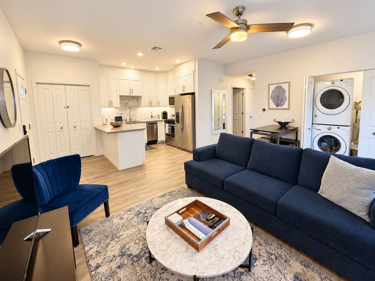 A modern apartment with a living room, kitchen, and laundry area.