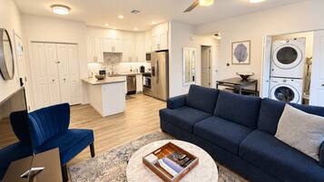 A modern apartment with a living room, kitchen, and laundry area.