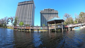 A waterfront view with two high-rise buildings, a wooden pier, and a gazebo. - DISNEY area CONDO 2 KING BEDS 2 BUNKS 2 BATHS Large 1350 sq ft Lake View 10th fl (Orlando)
