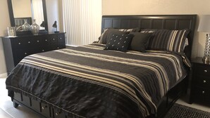A bedroom with a large bed, dark headboard, and a dresser with drawers. - Old Town Scottsdale  (Scottsdale)