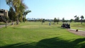 A golf course with a clear path, trees, and a distant mountain range. - Old Town Scottsdale  (Scottsdale)
