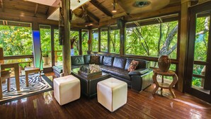 A spacious living area with a leather sofa, a coffee table, and a zebra-patterned rug.
