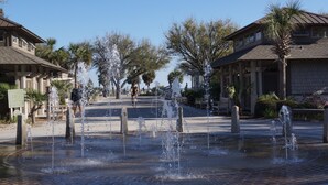 Ein Brunnen auf einem Platz, umgeben von Gebäuden.