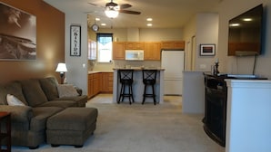 A compact kitchen with wooden cabinets, a central island with stools, a refrigerator, and a ceiling fan. - Condo conveniently located in the Heart of Old Town Florence (Florence)