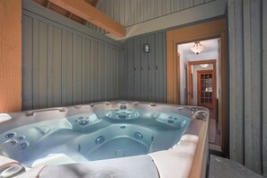 A hot tub in a room with wooden walls and a wooden door. - Mountain Star 16 - Ski in Walk out, Private Hot Tub, Fireplace (Whistler)