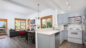 A modern kitchen with a central island, white cabinetry, and a built-in oven. - Mountain Star 16 - Ski in Walk out, Private Hot Tub, Fireplace (Whistler)