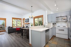 A modern kitchen with a central island, white cabinetry, and a built-in oven. - Mountain Star 16 - Ski in Walk out, Private Hot Tub, Fireplace (Whistler)