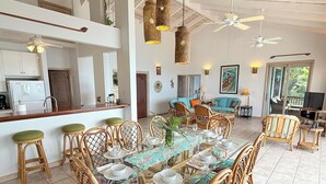 A spacious dining area with a large table set for a meal, surrounded by wicker chairs. - Bask in Beauty: Anole Offers Unmatched North Shore Views and a Pool Perfect for Relaxation (Cinnamon Bay)