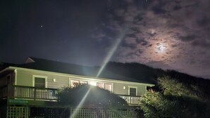 A house with a fenced driveway and a visible garage. - Cozy Cottage in Kitty Hawk with Gorgeous Ocean Views! (Kitty Hawk)