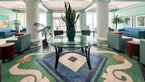 A spacious lobby with a glass table, blue sofas, and potted plants. -  Boardwalk Beach Resort, Ocean/Beach front, Loaded w Amenities, Park your car!! (Panama City Beach)