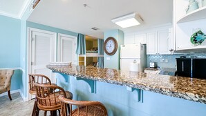 A kitchen with a granite countertop, white cabinets, and a built-in refrigerator. -  Boardwalk Beach Resort, Ocean/Beach front, Loaded w Amenities, Park your car!! (Panama City Beach)