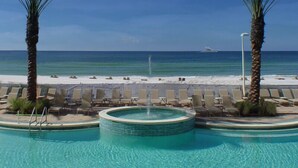 A pool area with lounge chairs and a hot tub, overlooking a beach and ocean. -  Boardwalk Beach Resort, Ocean/Beach front, Loaded w Amenities, Park your car!! (Panama City Beach)