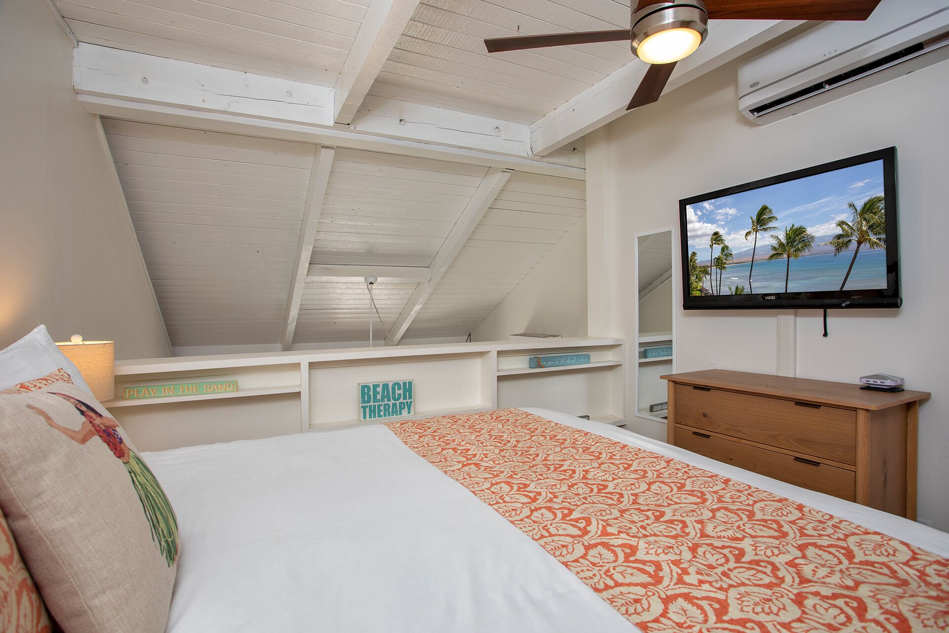 A bedroom with a bed, a ceiling fan, a TV, and a view of the sky.